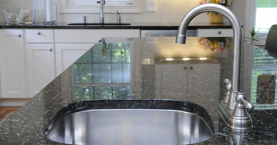 Na imagem vemos uma pia de cozinha. Como escolher entre granito escovado ou polido? Leia o artigo!